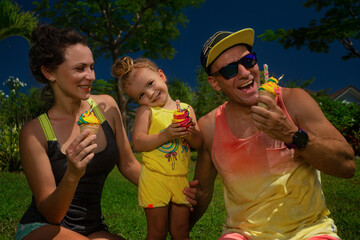 Obraz premium Parents and kid eating ice cream and having fun outside