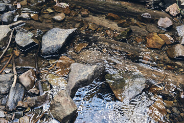 Mountain river surrounded by mountains. A waterfall flowing down from a Sheer cliffs . blue clear water of the river. Rocky stones and forest Alpine landscape