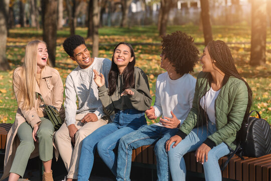 Teenagers having fun in public park, talking and laughing