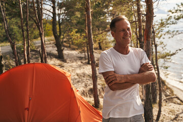 Smiling man relaxing in camping in wood