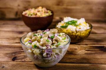 Set of festive mayonnaise salads on wooden table