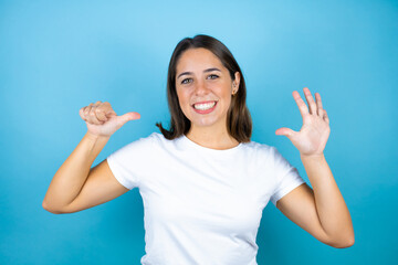 Young beautiful woman over isolated blue background showing and pointing up with fingers number six while smiling confident and happy