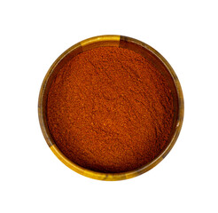 Top view of dry red chili pepper ground powder in a round wooden bowl isolated on white background.