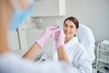 Cheerful spa client smiling before an injection