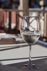 A glass of white wine on the table in the beach cafe.