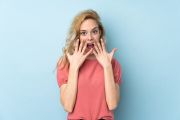 Young blonde woman isolated on blue background with surprise facial expression