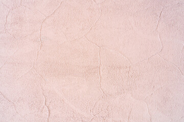 Peach wall of the building. Rough plaster surface. Abstract background.