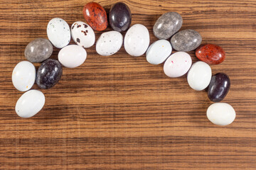 Colorful chocolate eggs on exotic natural wood background