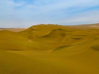 Fototapeta na wymiar Scenic sand dunes landscape in the peruvian desert. Sandy yellow waves in arid desert near Huacachina oasis, Peru.