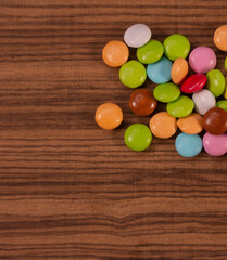 Small colorful chocolate tablets on exotic natural wood background
