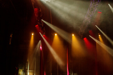 Stage lights. Several projectors in dark. A bright colored spotlight permeates the darkness. Light...