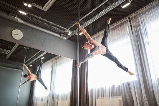 Muscular man dancing in a class with big window
