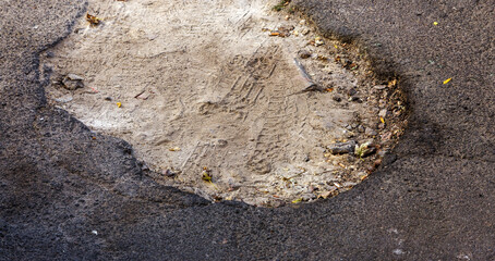 Damaged road, cracked asphalt sword with potholes and spots, Ukraine. Very bad asphalt road with large holes. Terrible technology construction roads. Numerous dangerous failures. Bad road