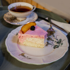 peach and berry mousse cake on plate with tea