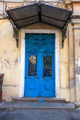 Old wooden door. Ancient antique wooden in an old wall. Ancient decorative wooden door. Historical art style facade of an elite expensive antique door. Wooden background, old front door, vintage eleme