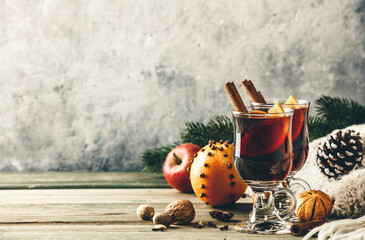 Mulled wine with spices and orange slices on wooden table, copy space