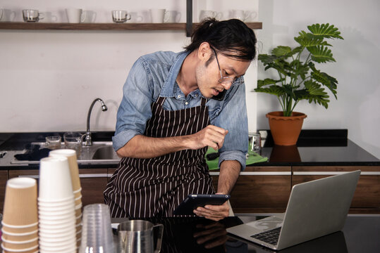 SME Coffee Shop Owner Busy Talking With Beverage Order On Mobile Device