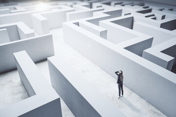 Young businesswoman in suit standing in concerete labyrinth.