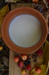 Ceramic mug with milk on the background old board, ranetka apples