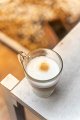 a cup of coffee on wooden table with work break time, food concept. Close up of a glass of hot Coffee Latte with nice milk form with copy space