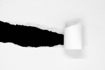 White ripped paper with twisted one side isolated on black background with copy space
