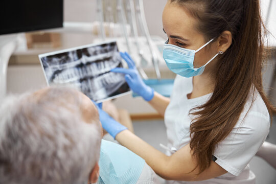 Professional dentist holding a dental x-ray of her patient
