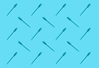 Naklejka premium Blue pens lie on a blue background. The concept of training, business, school, office. Minimalism, copy space, pattern.