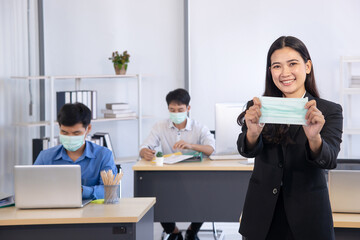 lady in formal dress show surgical  mask in office - prevention in pandemic era concept