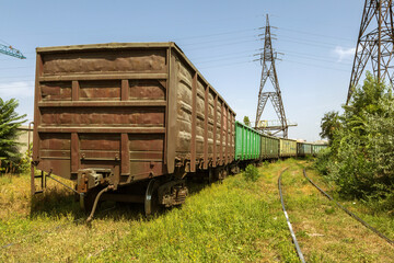 Fototapeta na wymiar Railway station with freight cars in industrial depot of the power plant. Colorful industrial landscape. Railway in depot. The railway platform. Heavy industry. Cargo transportation by railroad cars