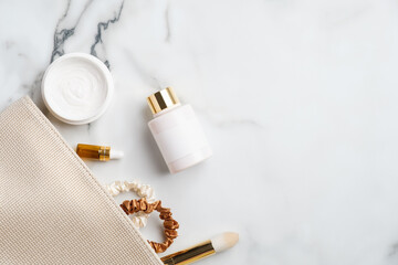 Makeup bag with natural cosmetic products set on marble desk. Flat lay, top view moisturizer cream,...