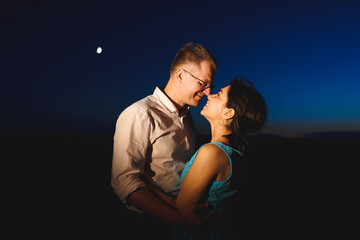 hugging couple and moon in sky