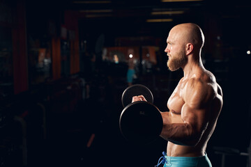 Strong young man exercising in the gym