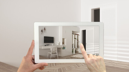 Augmented reality concept. Hand holding tablet with AR application used to simulate furniture and design products in empty interior with parquet floor, modern children bedroom