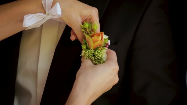 Wedding ceremony. Flowers for the groom's suit. Cockade