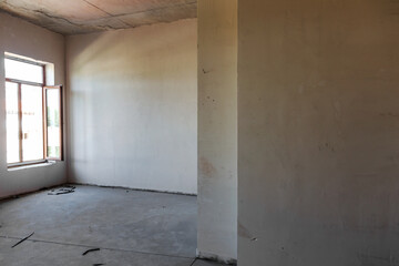 The plastered walls of the new apartment in the newly built house. Repair and construction of houses and apartments. Puttying walls inside the building. Apartment in the beginning of renovation