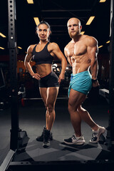 Fototapeta na wymiar Two beautiful bodybuilders posing at the gym
