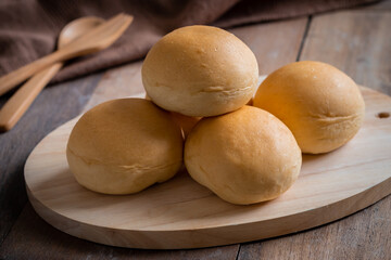 Bread roll or bun on wooden board.