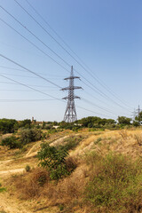 Power lines. Electric distribution station. High voltage power transmission tower of high voltage with wires in the afternoon in the steppe outside the city
