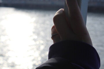 person looking at the water with engagement ring