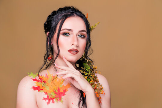 Trendy autumnal makeup . Fashion beauty model girl. Closeup portrait isolated on beige background with copy space