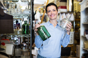 happy female holding glass jar in decoration and furniture store