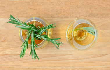 Top view of rosemary tea in couple of glass cups on wooden table