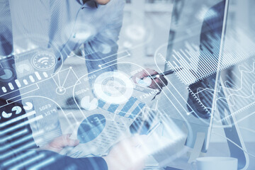 Technology theme hologram with man working on computer on background. High tech concept. Multi exposure.