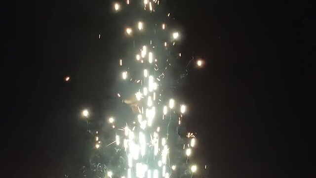 Colorful fountain fireworks stream into dark night