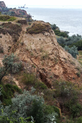 Landslide zone on Black Sea coast. Rock of sea rock shell. Zone of natural disasters during rainy season. Large masses of earth slip along slope of hill, destroy houses. Landslide - threat to life