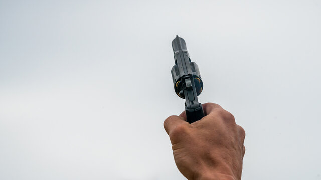 Hand holding a pistol to shoot into the air
