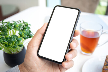 male hand holds phone with isolated screen in cafe