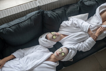 Young women having cucumber eye mask and looking relaxed