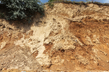 Landslide zone on Black Sea coast. Rock of sea rock shell. Zone of natural disasters during rainy season. Large masses of earth slip along slope of hill, destroy houses. Landslide - threat to life