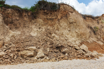 Landslide zone on Black Sea coast. Rock of sea rock shell. Zone of natural disasters during rainy season. Large masses of earth slip along slope of hill, destroy houses. Landslide - threat to life